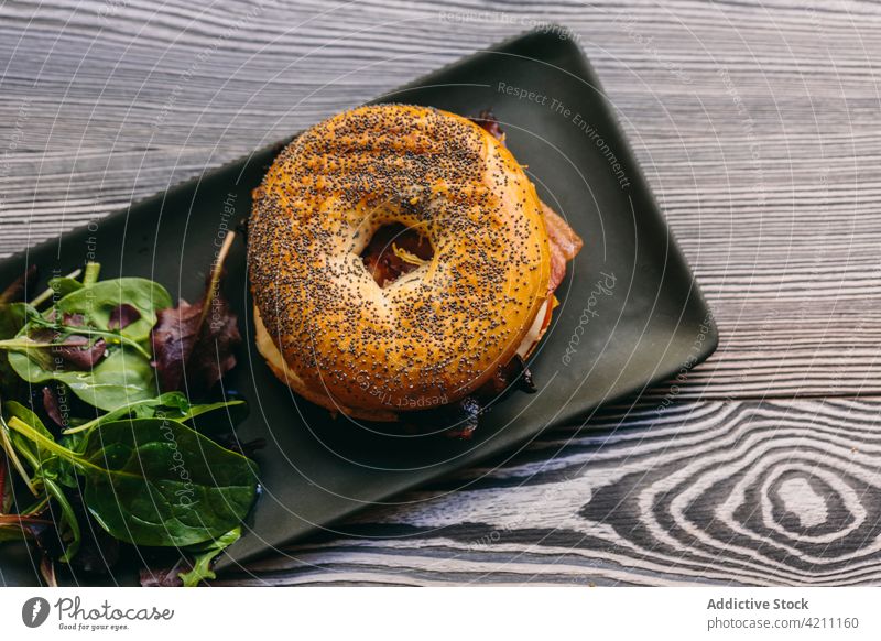 Leckeres Bagel-Sandwich auf dem Tisch im Café Belegtes Brot Fleisch dienen geschmackvoll Hähnchen appetitlich Lebensmittel Mahlzeit lecker Salatbeilage Teller