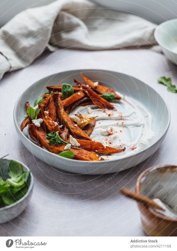 Süßkartoffelpommes in einer Schüssel auf dem Tisch süß Kartoffel Fries gebacken Knusprig Schalen & Schüsseln dienen Kraut geschmackvoll Lebensmittel Snack