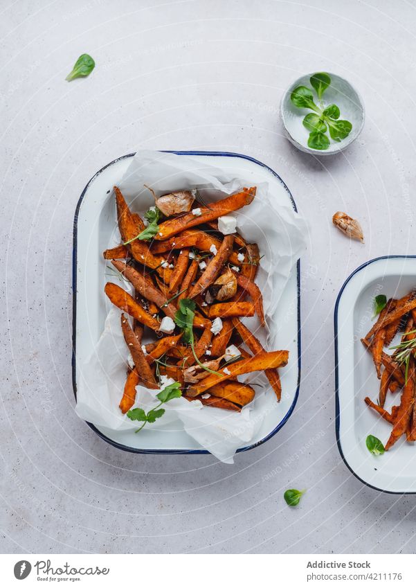 Süßkartoffelpommes in einer Schüssel auf dem Tisch süß Kartoffel Fries gebacken Knusprig Schalen & Schüsseln dienen Kraut geschmackvoll Lebensmittel Snack