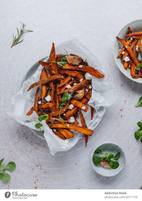 Süßkartoffelpommes in einer Schüssel auf dem Tisch süß Kartoffel Fries gebacken Knusprig Schalen & Schüsseln dienen Kraut geschmackvoll Lebensmittel Snack