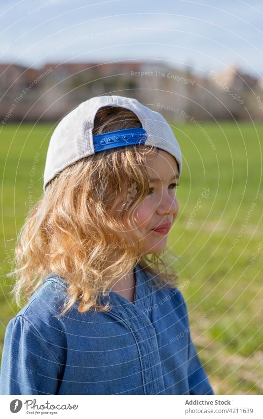 Trendy Mädchen in grasbewachsenen Wiese Feld Sommer Natur Stil Outfit ruhen Wochenende Gras sonnig tagsüber Kind lässig Mode trendy Verschlussdeckel Freiheit