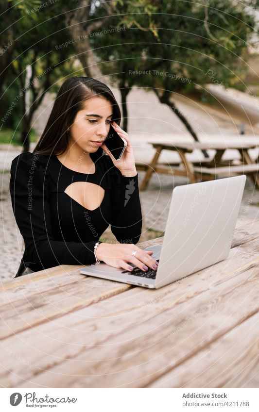 Geschäftsfrau bei der Arbeit im Stadtpark Frau abgelegen Park sprechen Smartphone reden Gespräch Telefonanruf Unternehmer Tisch Laptop Kommunizieren Gerät Anruf