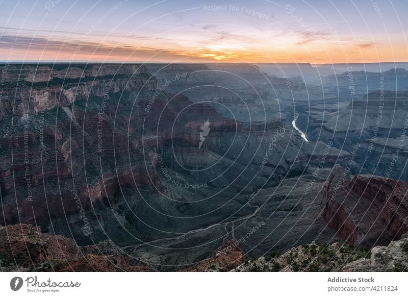 Felsige Schlucht mit Fluss unter buntem Himmel bei Sonnenuntergang Park felsig rau Landschaft Sonnenaufgang Natur Formation Umwelt grand canyon nationalpark