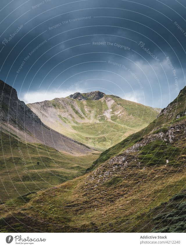 Grasbewachsene Berge in der Natur mit stürmischen Wolken Hochland Hügel bedeckt Tal Unwetter val d aran Katalonien Spanien Wiese wolkig Landschaft trist grau