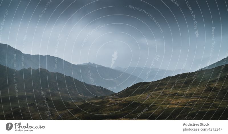 Grasbewachsene Berge in der Natur mit stürmischen Wolken Hochland Hügel bedeckt Tal Unwetter val d aran Katalonien Spanien Wiese wolkig Landschaft trist grau