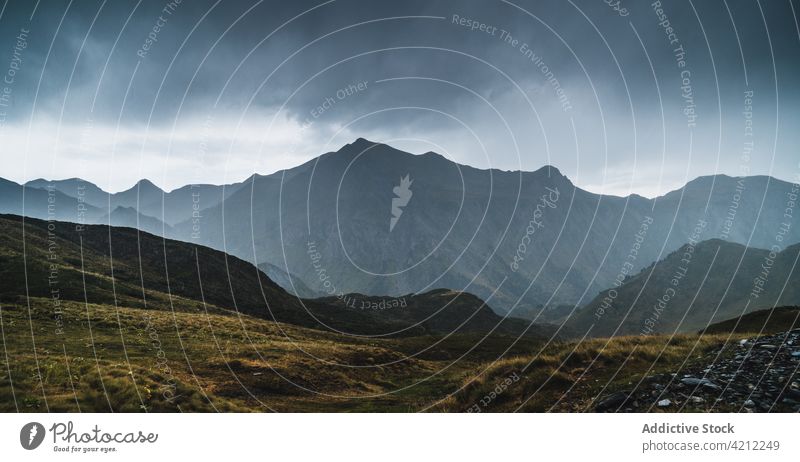 Grasbewachsene Berge in der Natur mit stürmischen Wolken Hochland Hügel bedeckt Tal Unwetter val d aran Katalonien Spanien Wiese wolkig Landschaft trist grau