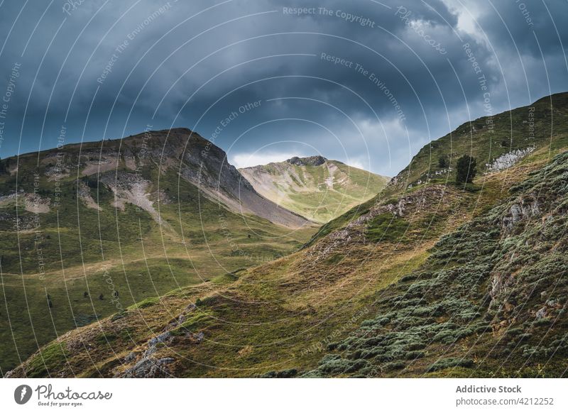 Grasbewachsene Berge in der Natur mit stürmischen Wolken Hochland Hügel bedeckt Tal Unwetter val d aran Katalonien Spanien Wiese wolkig Landschaft trist grau