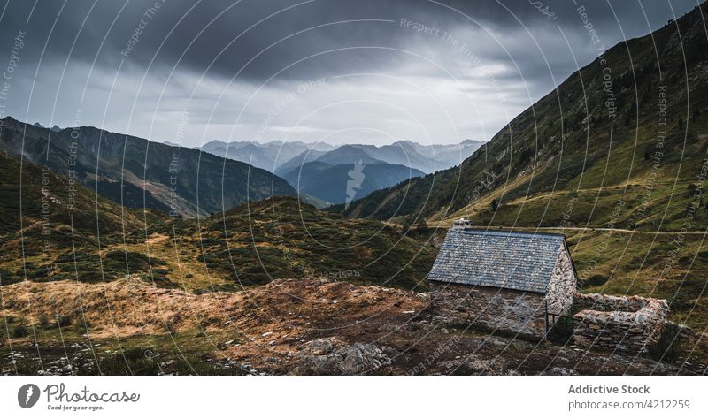 Kleine Hütte in grasbewachsenem bergigem Gelände an einem düsteren Tag Hochland Gras Tal aran Berge u. Gebirge Feld val d aran Spanien Katalonien Pyrenäen Natur