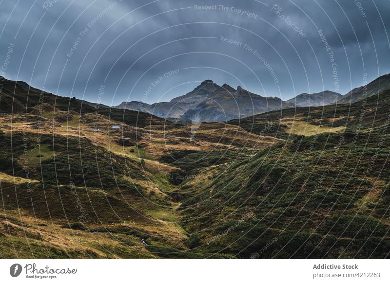 Grasbewachsene Berge in der Natur mit stürmischen Wolken Hochland Hügel bedeckt Tal Unwetter val d aran Katalonien Spanien Wiese wolkig Landschaft trist grau