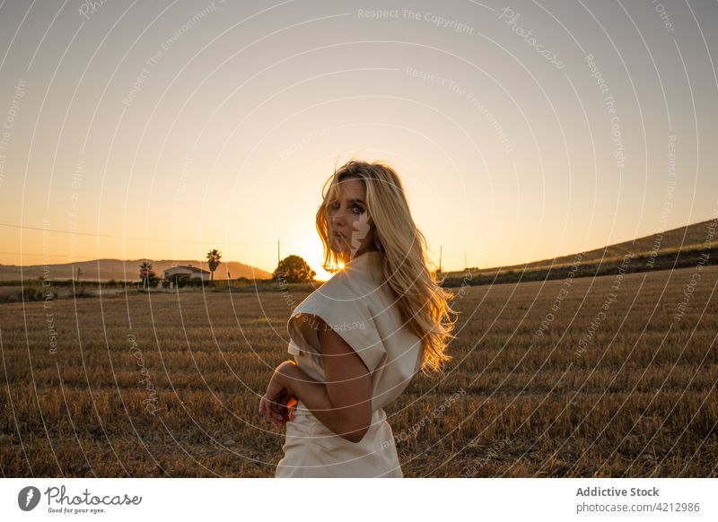 Gelassene Frau steht auf einem trockenen Feld in der Landschaft Gelassenheit friedlich sich[Akk] entspannen Wiese ländlich Sommer Harmonie Windstille Natur jung