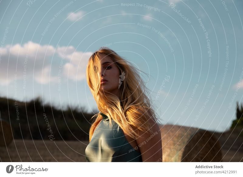 Gelassene Frau steht auf einem trockenen Feld in der Landschaft Gelassenheit friedlich sich[Akk] entspannen Wiese ländlich Sommer Harmonie Windstille Natur jung