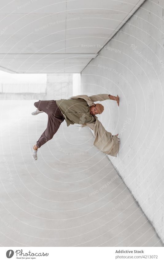 Aktiver Mann führt Breakdance-Tricks in der Stadt vor Tanzen Gleichgewicht Hip-Hop Tänzer urban ausführen Freestyle männlich Großstadt sich[Akk] bewegen Straße