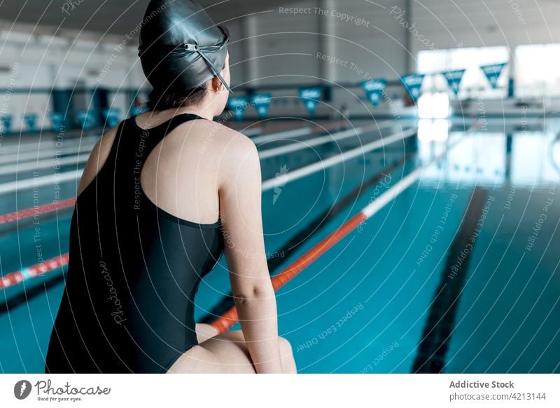 Schwimmer auf dem Beckenrand sitzend Sport Wasser Frau Pool Athlet jung Badebekleidung Training blau Menschen Verschlussdeckel Konkurrenz Person Lifestyle