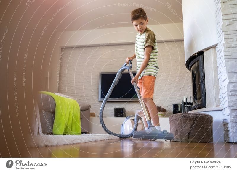 Junge staubsaugt Boden zu Hause Staubsauger Stock Staubsaugen Hausarbeit Hausarbeiten Hilfe Lernen Familie Menschen Kind Sohn Kinder Lifestyle elementar