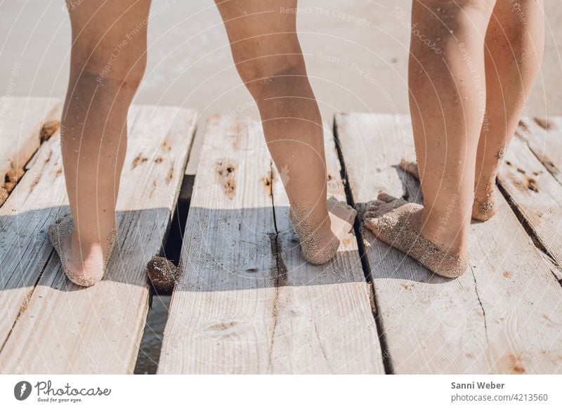 Kinder stehen auf dem Steg am Meer Kindheit Spielen Familie Glück Freude Farbfoto Außenaufnahme Fröhlichkeit Natur Zusammensein Strand Wasser fuesse Sommer