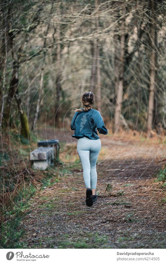 Sportliche Frau läuft im Wald laufen sportlich aktiv Training Fitness Sportkleidung passen Wälder Aktivität Läufer Sportlerin joggen Gesundheit Weg Nachlauf