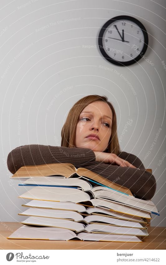 Studentin mit Büchern und Uhr Buch Mädchen Bildung Stress Alarm Schreibtisch Prüfung müde Arbeit Teenager Tisch weiblich Schule Müdigkeit Kaukasisch jung Frau