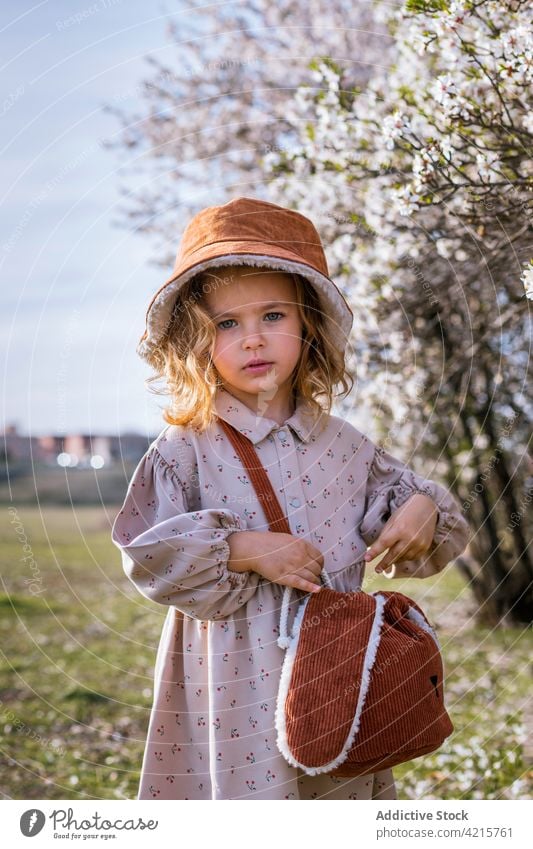 Nettes Mädchen in blühendem Frühlingsgarten stehend Garten Blütezeit Baum niedlich Kind Blume Park Natur bezaubernd Kindheit charmant Hut Kleid unschuldig