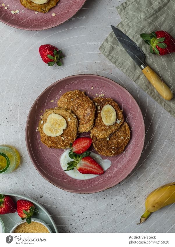 Mit Bananenpfannkuchen und ein paar Erdbeerstücken belegen Dessert süß Frühstück Lebensmittel Erdbeeren Zucker Sahne selbstgemacht Amerikaner lecker Pfannkuchen