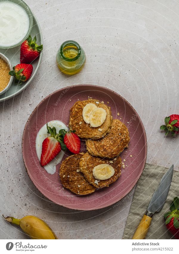 Mit Bananenpfannkuchen und ein paar Erdbeerstücken belegen Dessert süß Frühstück Lebensmittel Erdbeeren Zucker Sahne selbstgemacht Amerikaner lecker Pfannkuchen