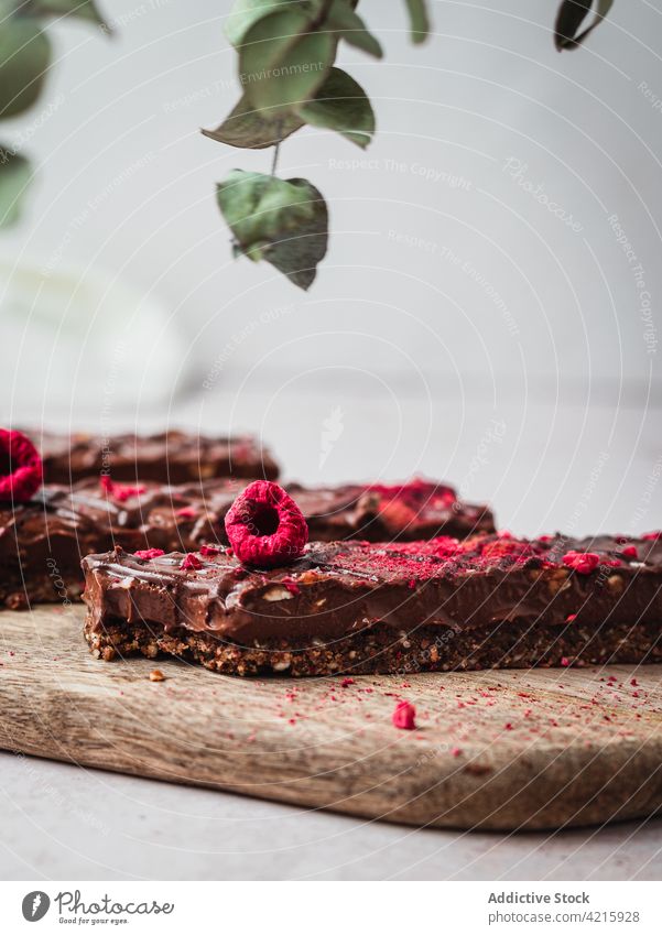 Mehrere Schokoladentafeln mit Himbeeren auf einem Tisch Dessert süß Lebensmittel Snack Kakao Bar geschmackvoll braun lecker vereinzelt Bonbon Spielfigur dunkel