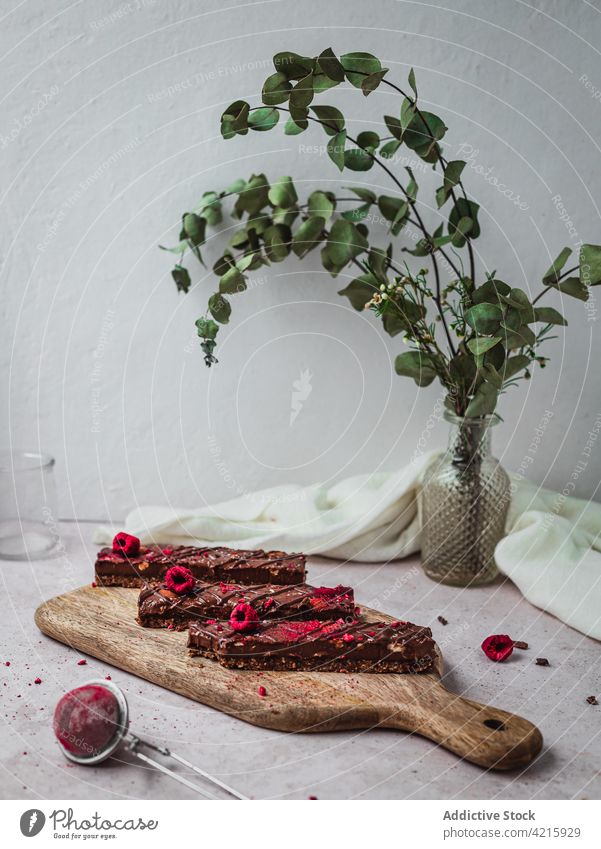 Mehrere Schokoladentafeln mit Himbeeren auf einem Tisch Dessert süß Lebensmittel Snack Kakao Bar geschmackvoll braun lecker vereinzelt Bonbon Spielfigur dunkel