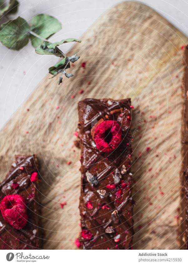 Mehrere Schokoladentafeln mit Himbeeren auf einem Tisch Dessert süß Lebensmittel Snack Kakao Bar geschmackvoll braun lecker vereinzelt Bonbon Spielfigur dunkel