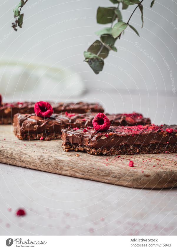 Mehrere Schokoladentafeln mit Himbeeren auf einem Tisch Dessert süß Lebensmittel Snack Kakao Bar geschmackvoll braun lecker vereinzelt Bonbon Spielfigur dunkel