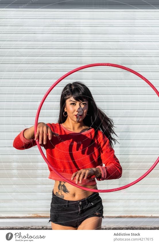 Tänzerin dreht Hula-Hoop-Reifen auf dem Bürgersteig spinnen Tanzen aktiv passen Tattoo Frau herumwirbeln Bewegung Choreographie Schatten Körper selbstbewusst