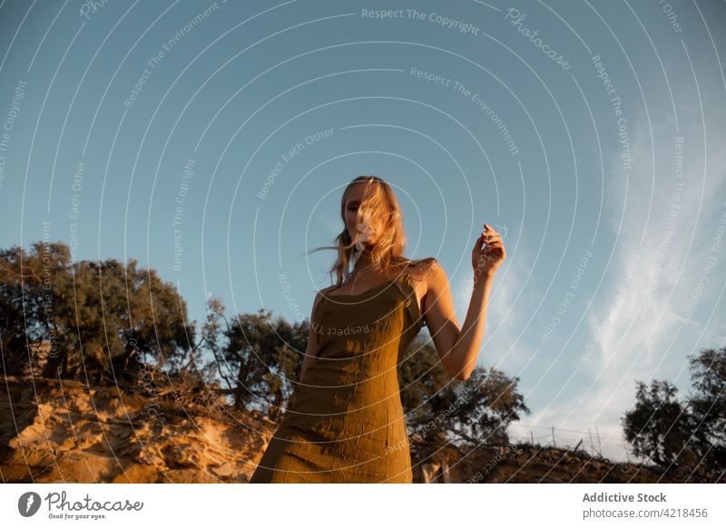 Junge Frau steht abends auf sandigem Boden Natur Sand Berghang friedlich Körperhaltung sorgenfrei Harmonie natürlich ruhig Gelassenheit blond vegetieren