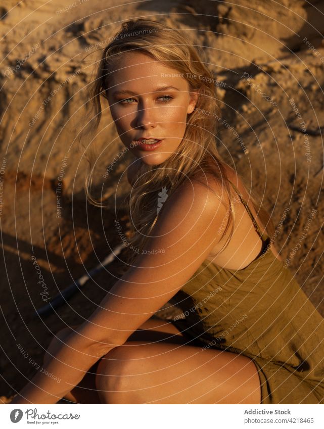 Junge Frau sitzt abends auf sandigem Boden Natur Sand Berghang friedlich Körperhaltung sorgenfrei Harmonie natürlich ruhig Gelassenheit blond vegetieren