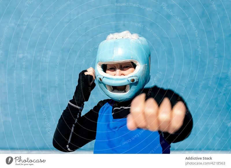 Ältere Sportlerin mit Boxhelm und Handschützern Boxsport Senior umhüllen schützend Schutzhelm Kopfbedeckung Inhalt reif Training heiter Frau sportlich aktiv