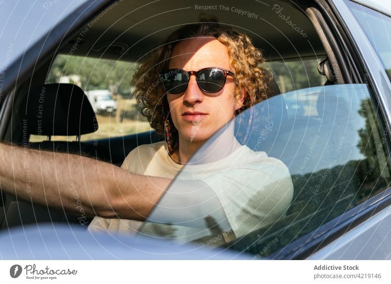 Mann mit Sonnenbrille fährt Auto PKW Laufwerk Stil Automobil Fenster selbstbewusst trendy männlich jung ernst Fahrer Fahrzeug Brille Behaarung Lifestyle Verkehr