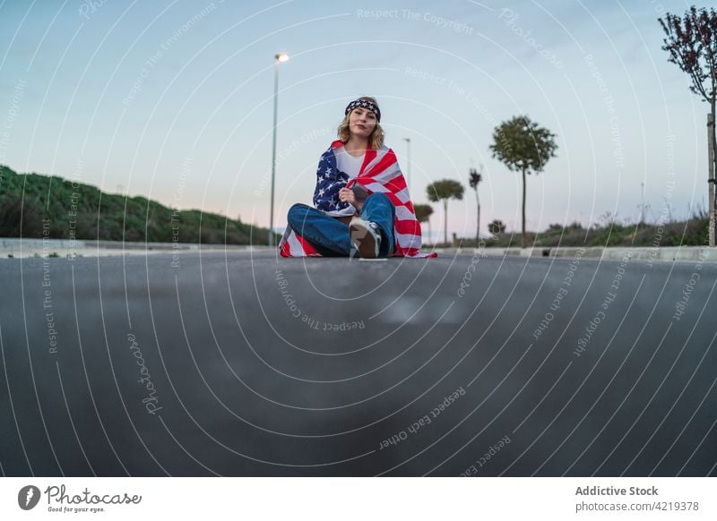 Amerikanische Frau mit Flagge auf der Straße sitzend Fahne Patriotin sorgenfrei umhüllen national Symbol Sonnenuntergang Freiheit Amerikaner USA amerika