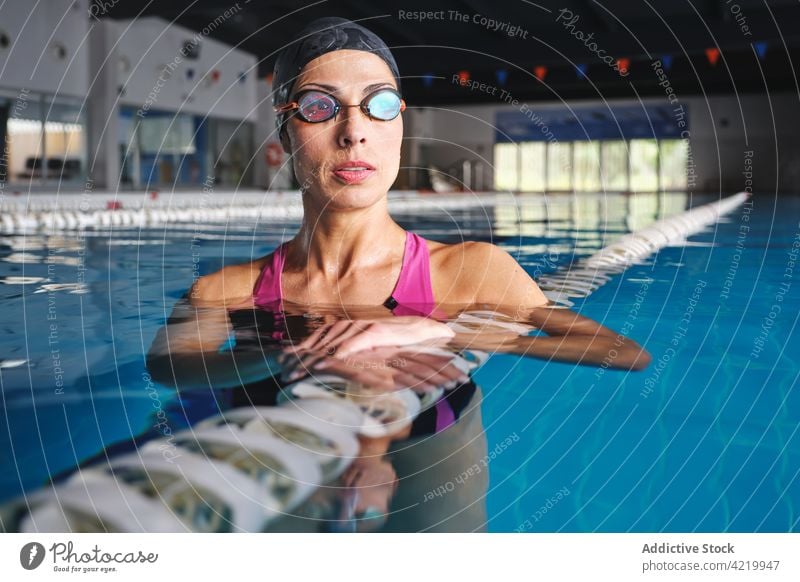 Schwimmerin im Badeanzug im Pool während einer Trainingspause Sport Wellness Pause nachdenken Frau Porträt professionell Fahrspur Linie fliegend Markierung