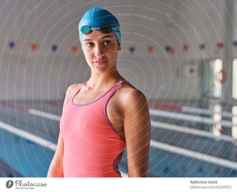 Sportlerin in Badeanzug und Schwimmbrille am Schwimmbad Schwimmer achtsam Schutzbrille Badebekleidung Wellness Vitalität Pool Frau Porträt Körper Schwimmsport