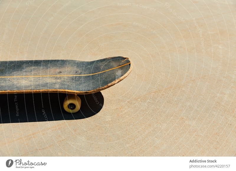 Nahaufnahme eines abgenutzten Skateboards auf Betonpflaster Schlittschuhlaufen Holzplatte Skatepark im Freien Licht Stil Sonnenuntergang entspannend Straße