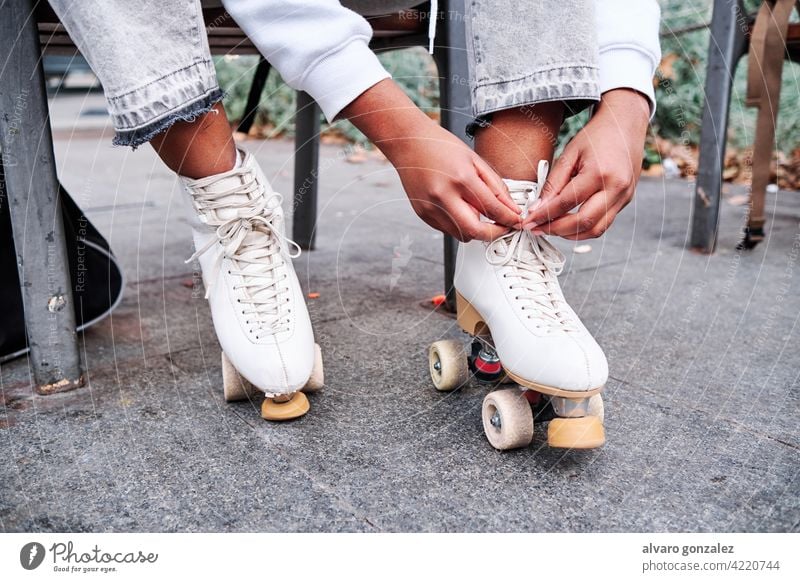 Frau bindet ihre Rollschuhschnürsenkel. che Rolle Schlittschuh Kopplungsbindung Schnürsenkel Hobby aktiv Übung sportlich Rollschuhlaufen entspannend Gerät