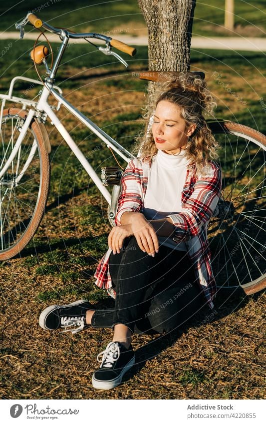 Sorglose Frau genießt sonnigen Tag im Park Fahrrad genießen verträumt sorgenfrei Garten Sommer Baum ruhig friedlich sitzen ruhen Harmonie charmant Windstille