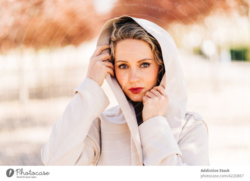 Stilvolle Frau geht entlang einer Allee im Park Gasse Spaziergang Kleid elegant Anmut Garten Baum Mantel charmant Natur trendy Weg sonnig Sonnenlicht Saison