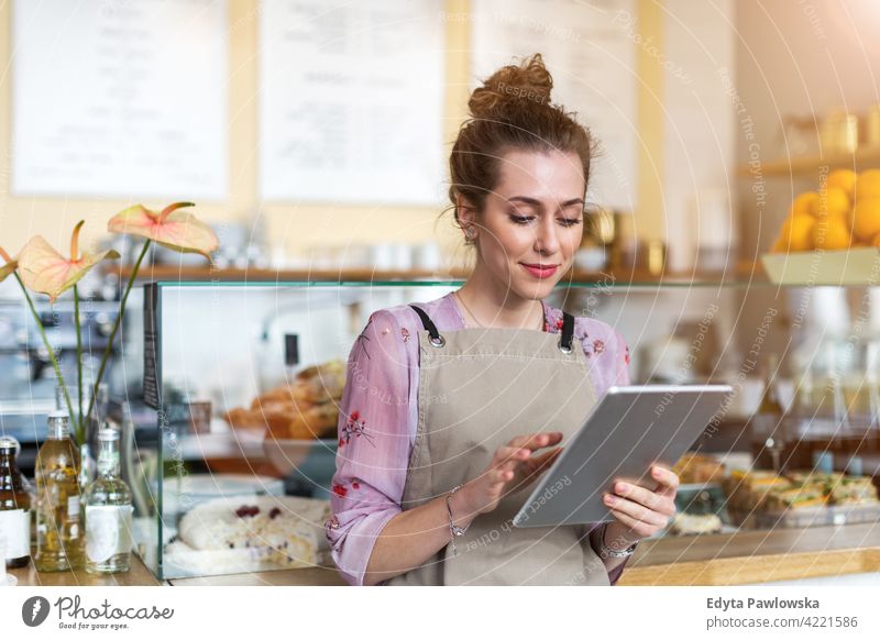 Junge Frau arbeitet in einem Café Menschen junger Erwachsener lässig attraktiv Lächeln Glück im Innenbereich Kaukasier zahnfarben genießend Restaurant Schürze