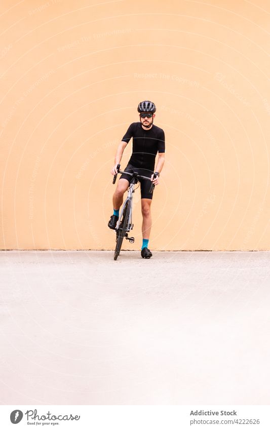 Radfahrer mit Fahrrad auf städtischem Bürgersteig Sport professionell Stil maskulin Spaziergang Straßenbelag urban Mann Verkehr Fahrzeug Kniestrümpfe Schutzhelm