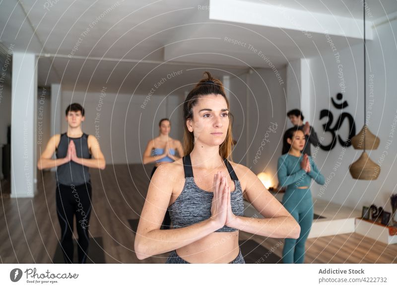 Frau übt Yoga während einer Gruppenstunde im Studio Klasse Lektion üben Menschen Zusammensein Berg-Pose Menschengruppe Wellness Asana Windstille Zen Energie