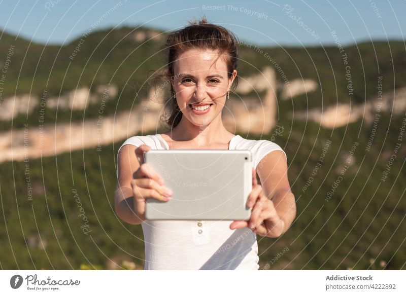 Lächelnde Frau nimmt Selfie auf Tablet im Hochland Berge u. Gebirge reisen Tablette Selbstportrait Gedächtnis Sommer Urlaub Moment Reisender fotografieren Natur