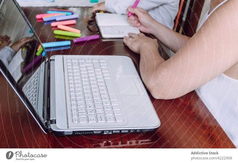 Crop Mutter und Kind zeichnen zusammen zu Hause Zusammensein Kinderbetreuung Markierung Filzstift heimwärts kreativ Bildung Notebook Tisch wenig Kindheit Hobby