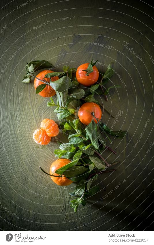 Reife Mandarine mit Blättern auf grünem Hintergrund Frucht Zitrusfrüchte tropisch exotisch natürlich reif Laubwerk Vitamin Aroma saftig gesunde Ernährung frisch