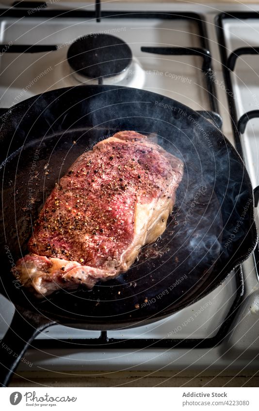 Bratpfanne mit leckerem Rindersteak und Gewürzen Pfanne Steak Fleisch Rindfleisch appetitlich braten Knoblauch Herd Gas Aroma Verdunstung Butter geschmolzen