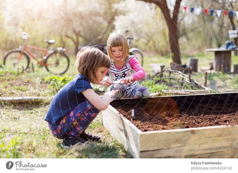 Zwei kleine Mädchen bei der Gartenarbeit im städtischen Gemeinschaftsgarten Bewässerung Gießkanne Wasser städtischer Garten Umweltschonung