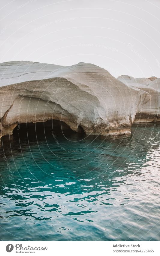 Felsige, unebene Küste, umspült von kräuselndem Meer Meeresufer kurvenreich Natur felsig MEER malerisch Strandpromenade sarakiniko Milos Blauer Himmel rau Ufer