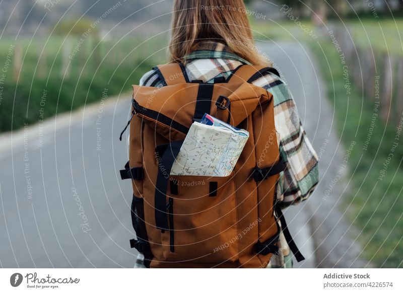 Crop-Tourist mit Papierkarte im Rucksack auf der Straße Landkarte Route Regie Fernweh erkunden reisen Frau Landschaft Wanderer Reiseroute Ausflug Reisender